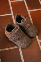 Baby Wool Camel – Wool baby booties – Bisgaard: two booties on a tiled floor.