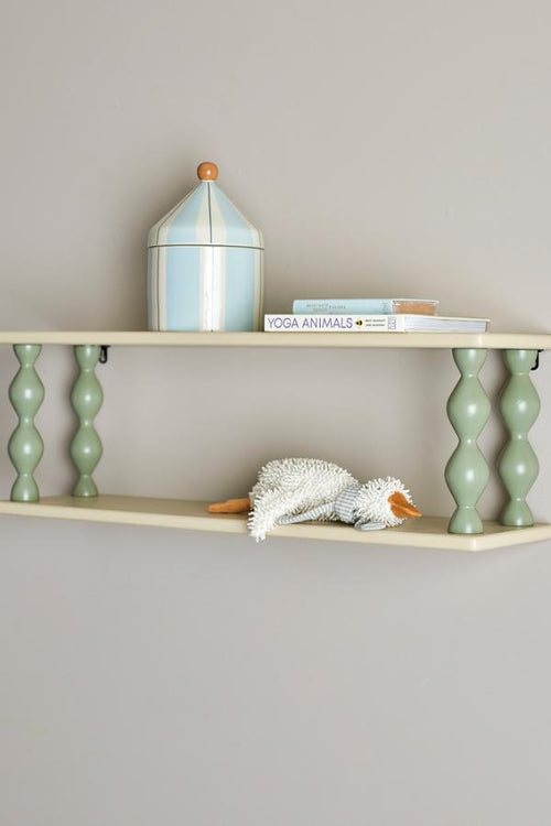 Bibiola Shelf Multi – Bloomingville MINI: Wandregal an der Wand mit Büchern und einer kleinen Lampe.
