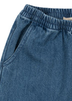 Denim broek Magot – Denim Blue – Konges Sløjd: detail van de elastische tailleband en steekzak van de denimbroek.